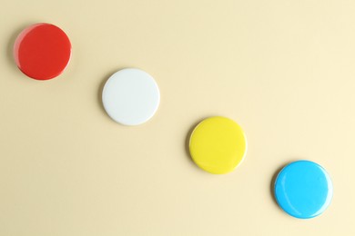 Photo of Colorful button badges on beige background, flat lay. Mockup for design