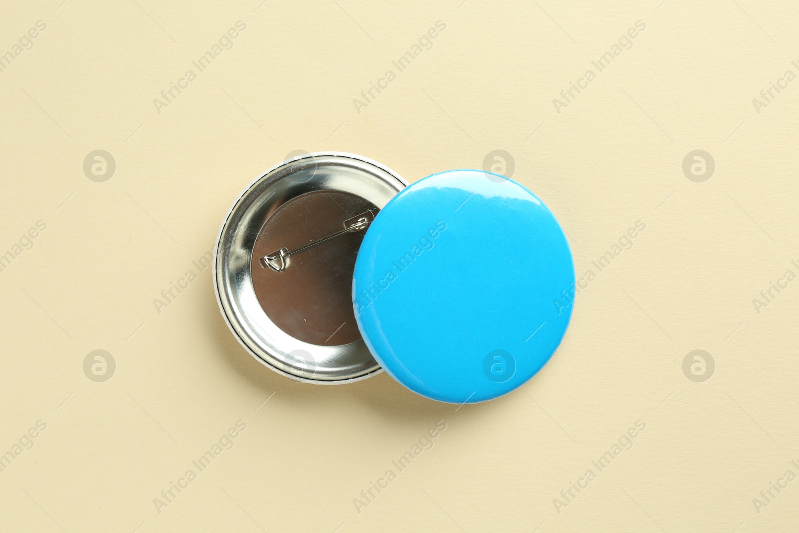 Photo of Button badges on beige background, flat lay. Mockup for design