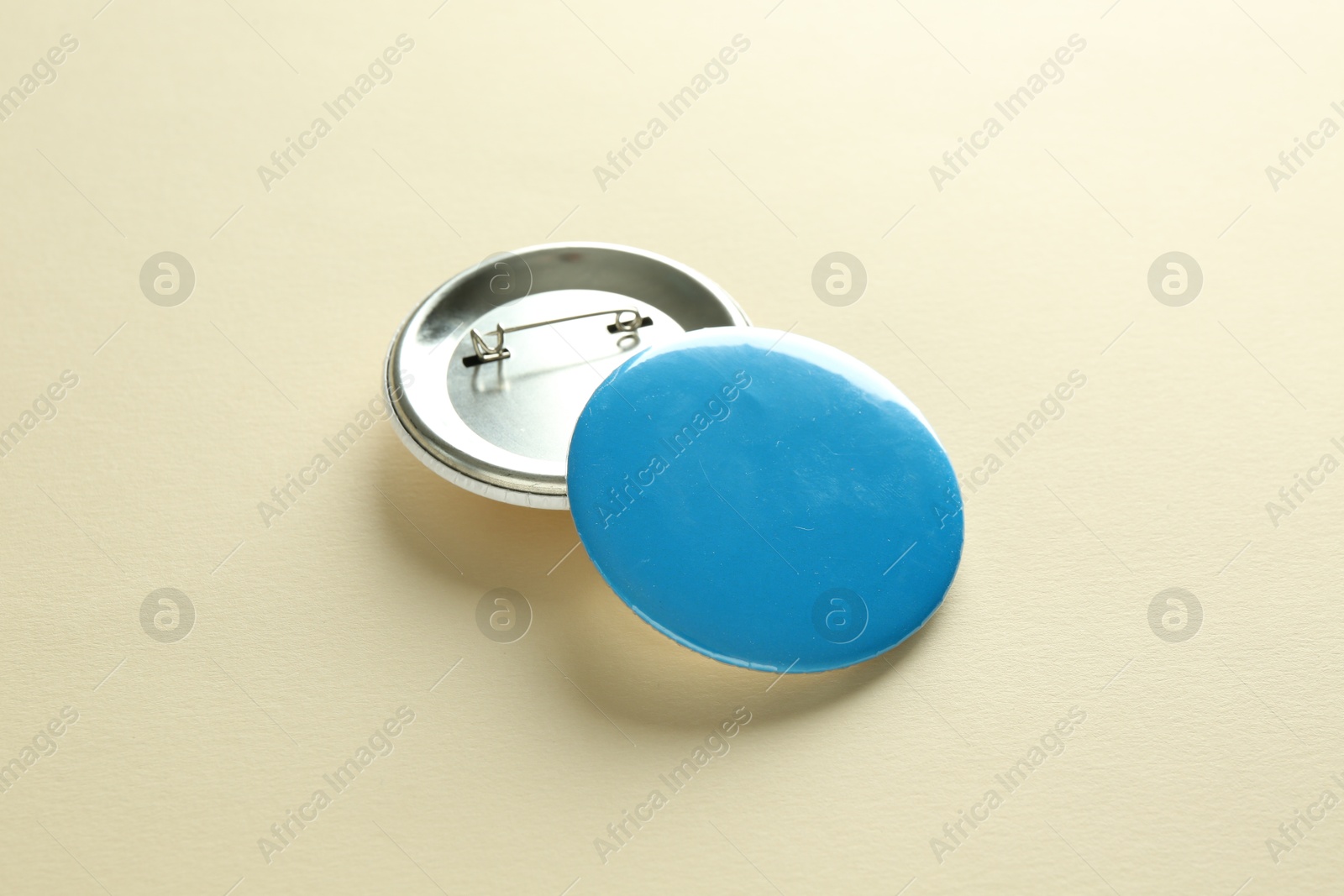 Photo of Button badges on beige background. Mockup for design