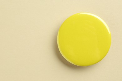 Yellow button badge on beige background. Mockup for design