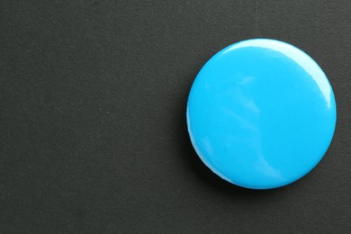 Photo of Blue button badge on black background, top view. Mockup for design