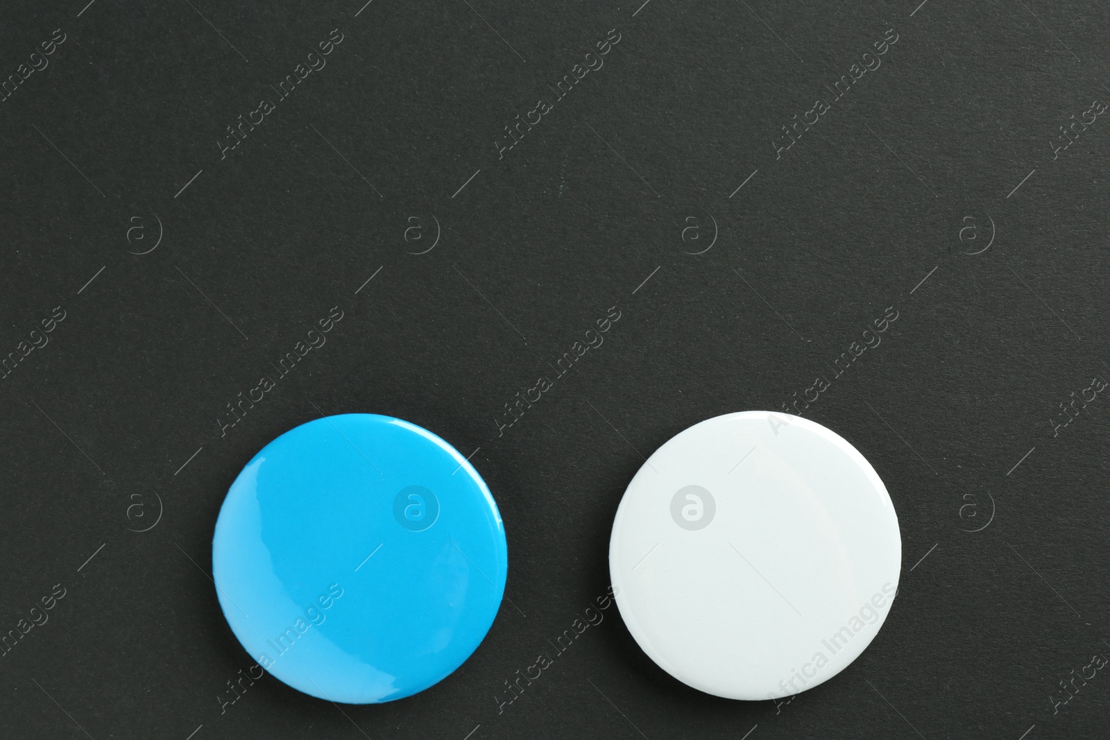 Photo of Button badges on black background, flat lay. Mockup for design