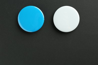 Button badges on black background, flat lay. Mockup for design