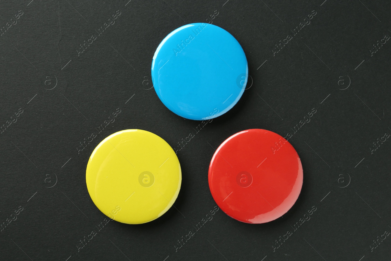 Photo of Button badges on black background, flat lay. Mockup for design