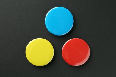 Button badges on black background, flat lay. Mockup for design