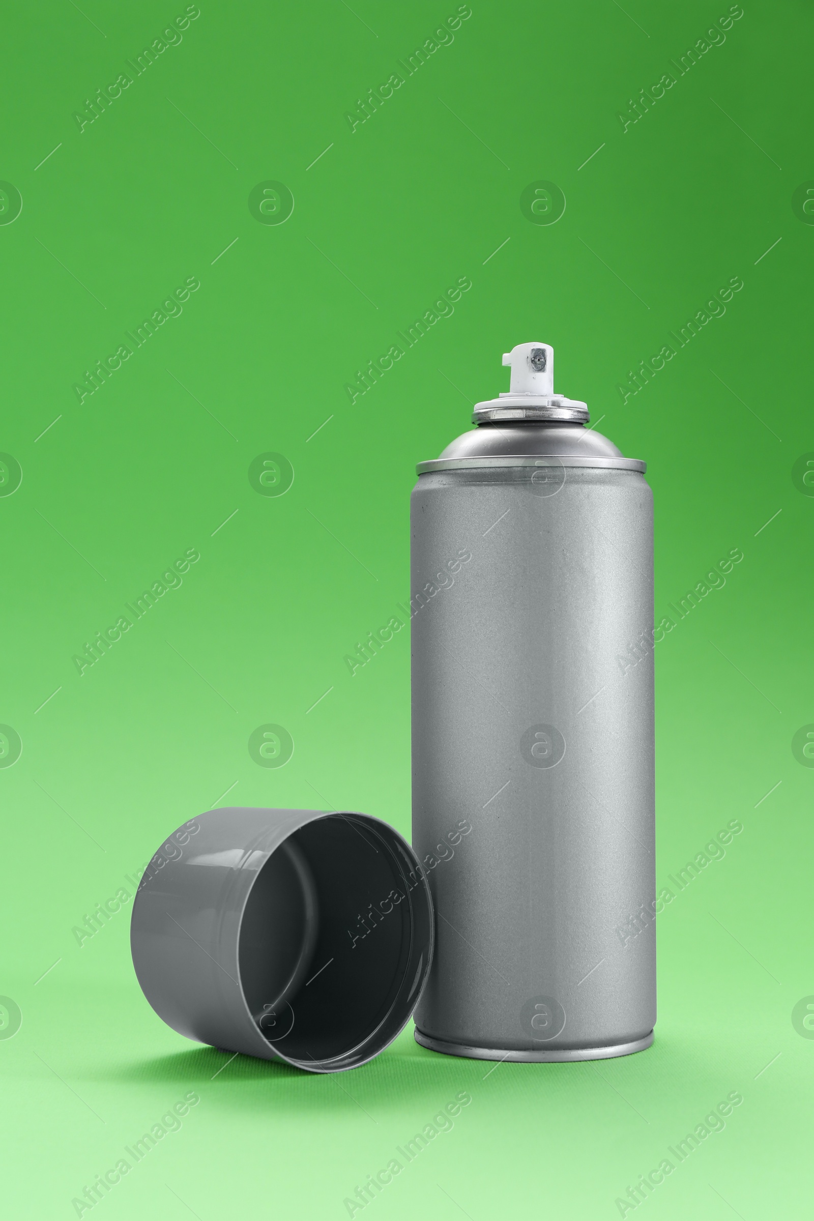 Photo of Gray spray paint can on green background