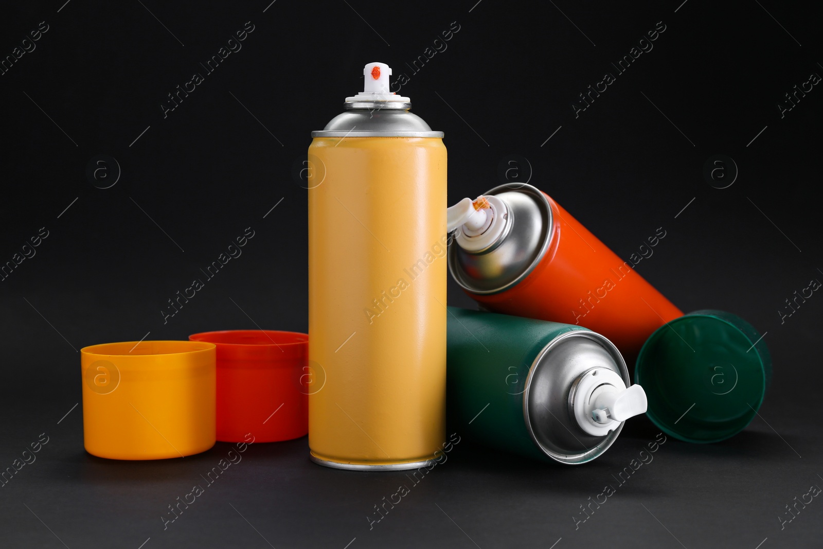 Photo of Many spray paint cans on dark gray background