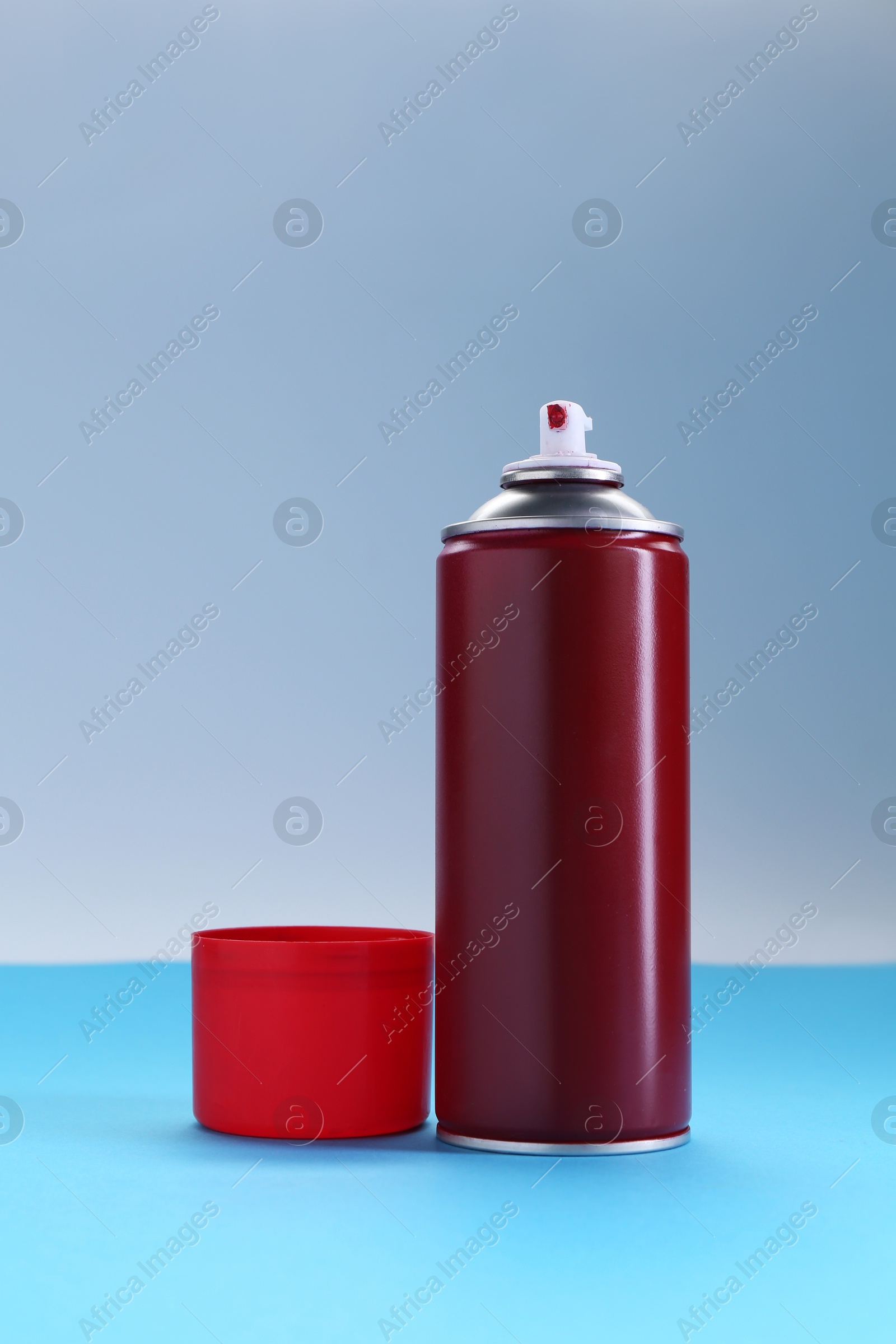 Photo of Red spray paint can on color background