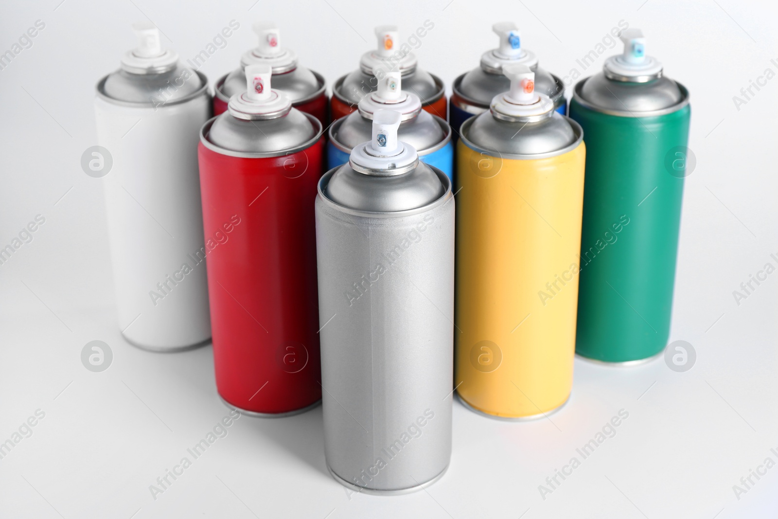 Photo of Cans of spray paint on white background