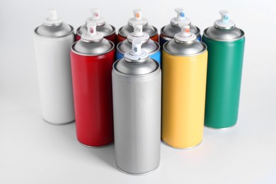 Photo of Cans of spray paint on white background