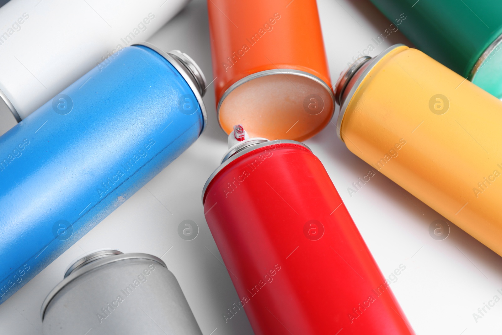 Photo of Cans of spray paint on white background