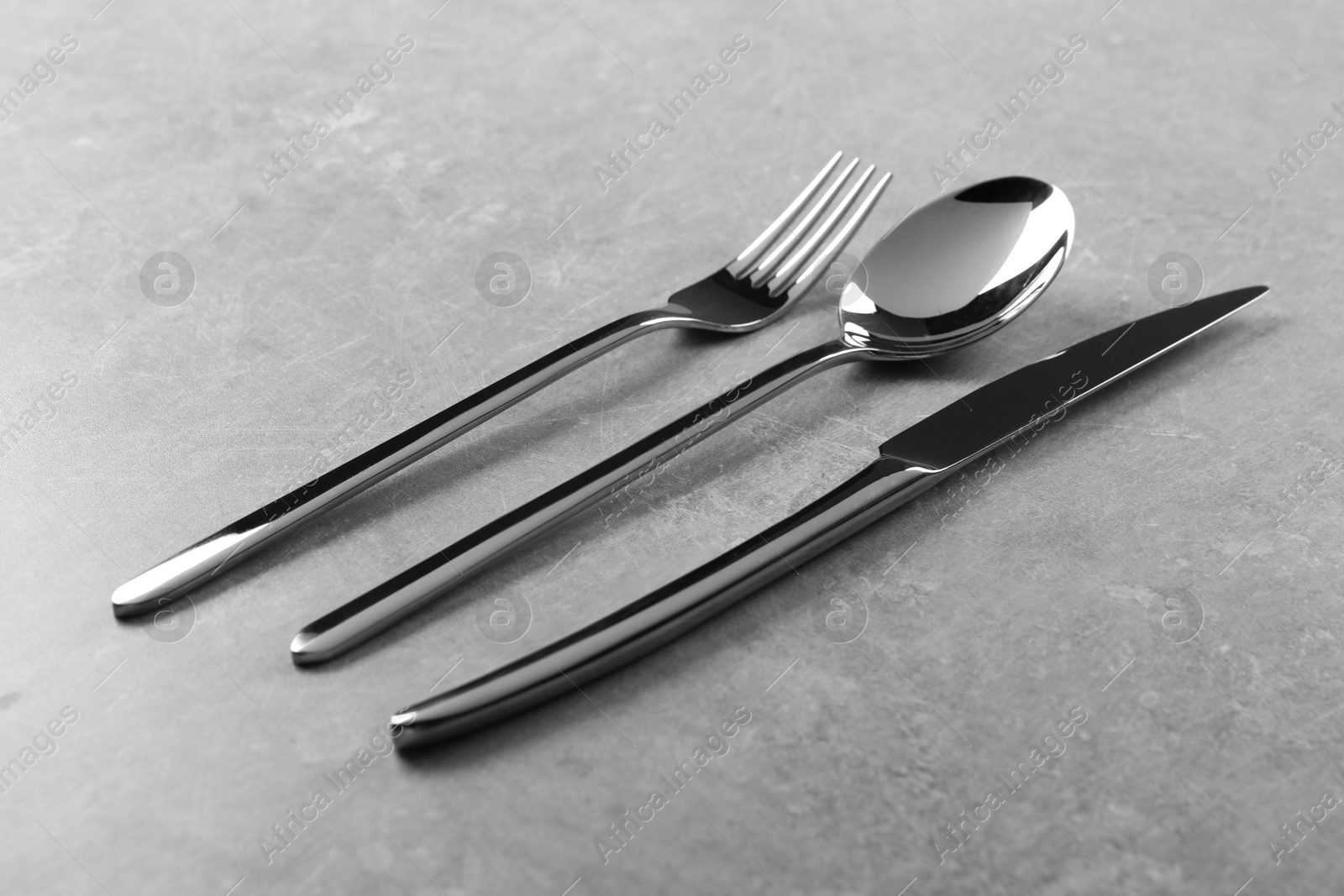 Photo of Stylish silver cutlery set on grey table