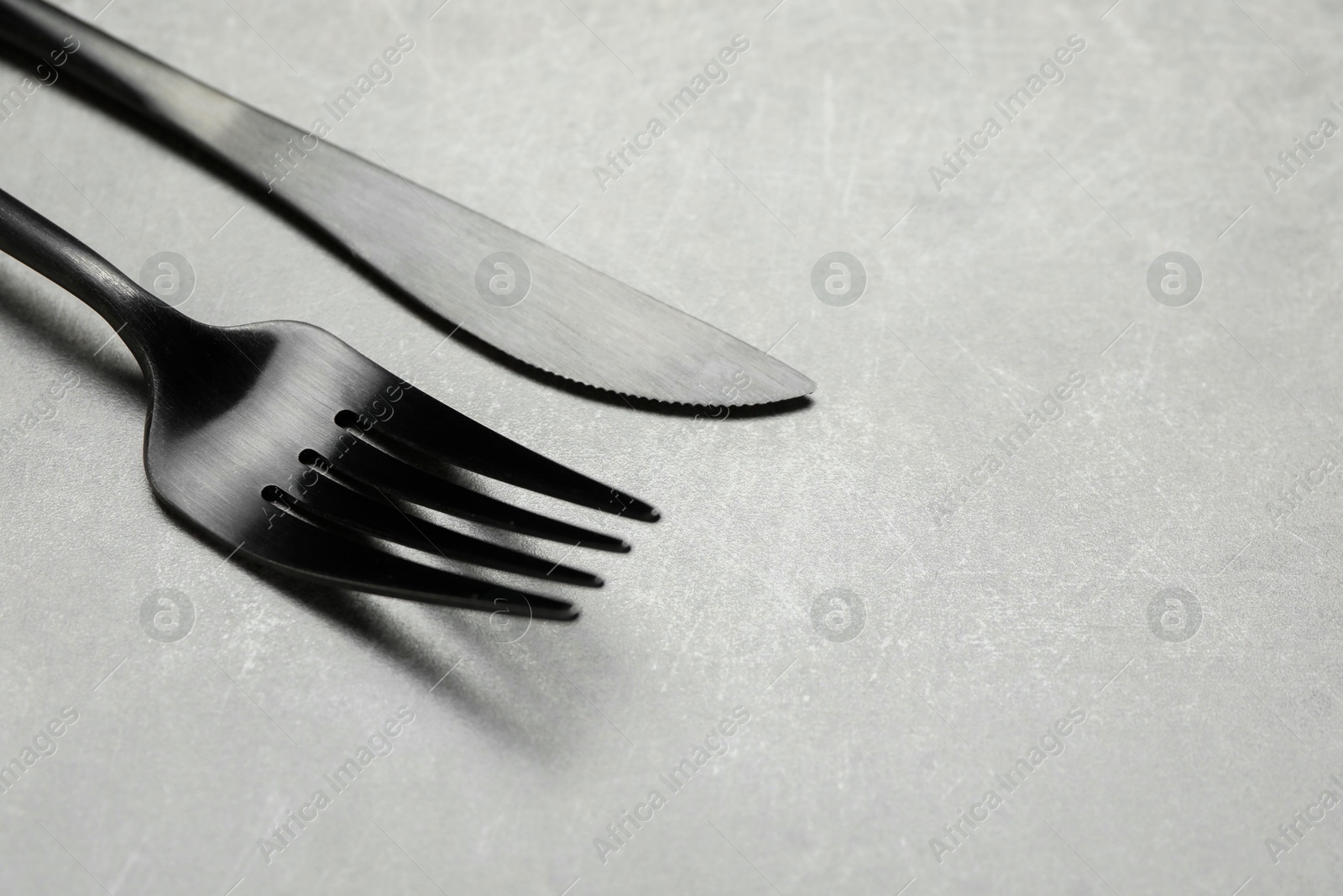 Photo of Stylish cutlery on grey table, closeup. Space for text