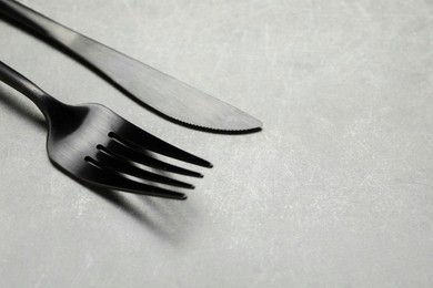 Photo of Stylish cutlery on grey table, closeup. Space for text