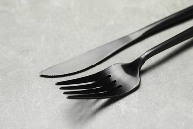 Stylish cutlery. Fork and knife on grey table, closeup