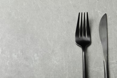 Photo of Stylish cutlery on grey table, top view. Space for text