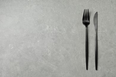 Stylish cutlery on grey table, top view. Space for text