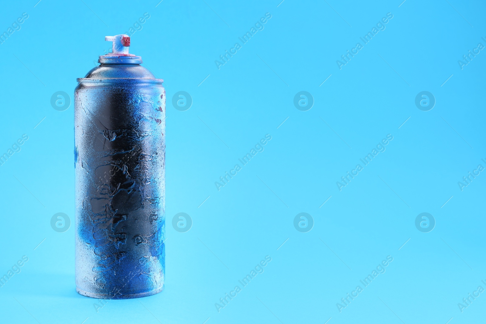 Photo of Spray paint can on light blue background, space for text