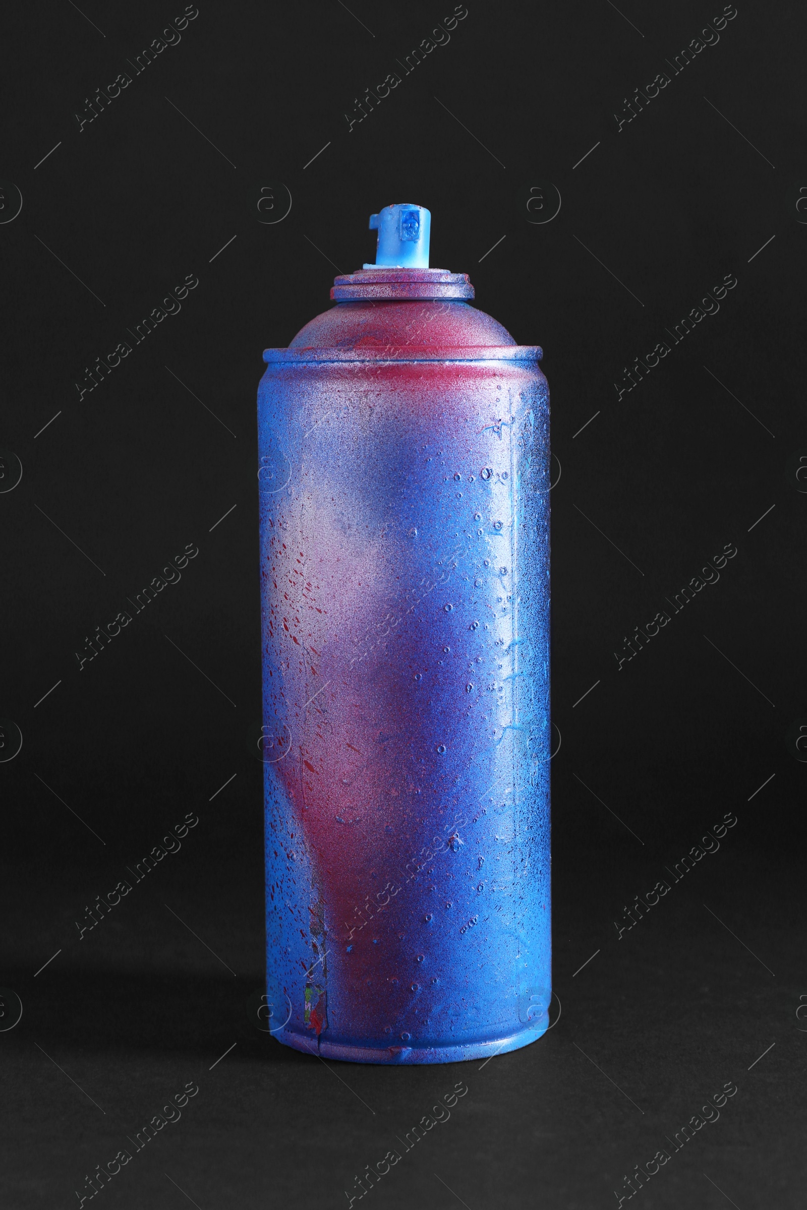 Photo of One spray paint can on dark background