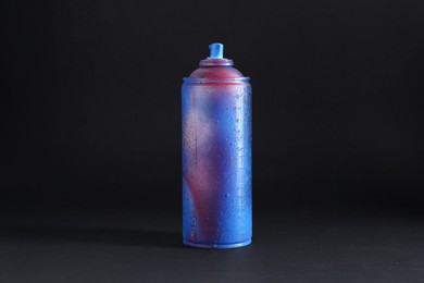 Photo of One spray paint can on dark background