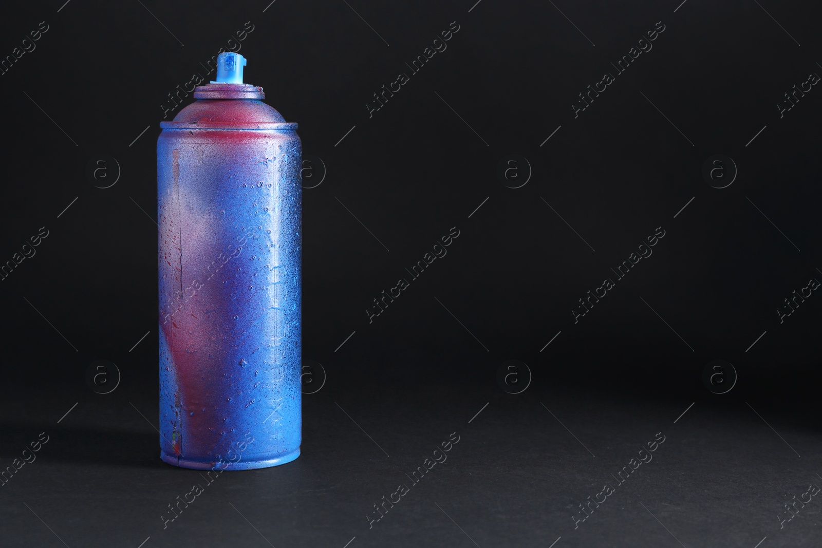 Photo of One spray paint can on dark background, space for text