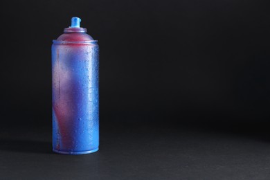 One spray paint can on dark background, space for text