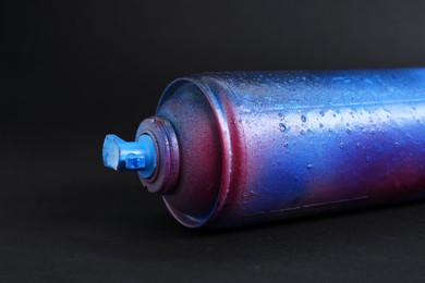 One spray paint can on dark background, closeup