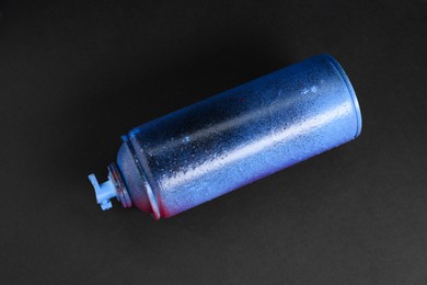 Photo of One spray paint can on dark background, top view