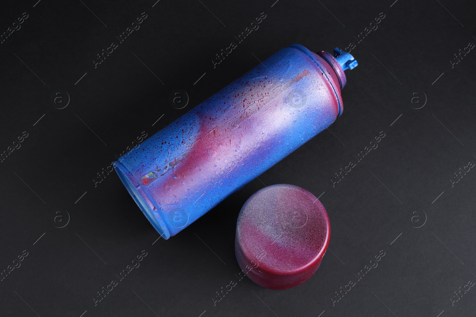 Photo of One spray paint can with cap on dark background, above view