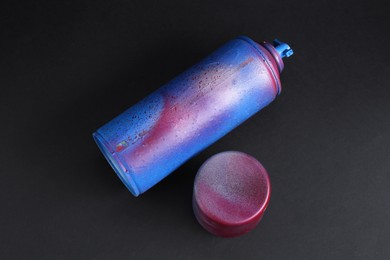 One spray paint can with cap on dark background, above view