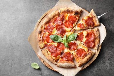 Tasty pepperoni pizza with basil on grey table, top view. Space for text