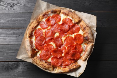 Tasty pepperoni pizza on black wooden table, top view