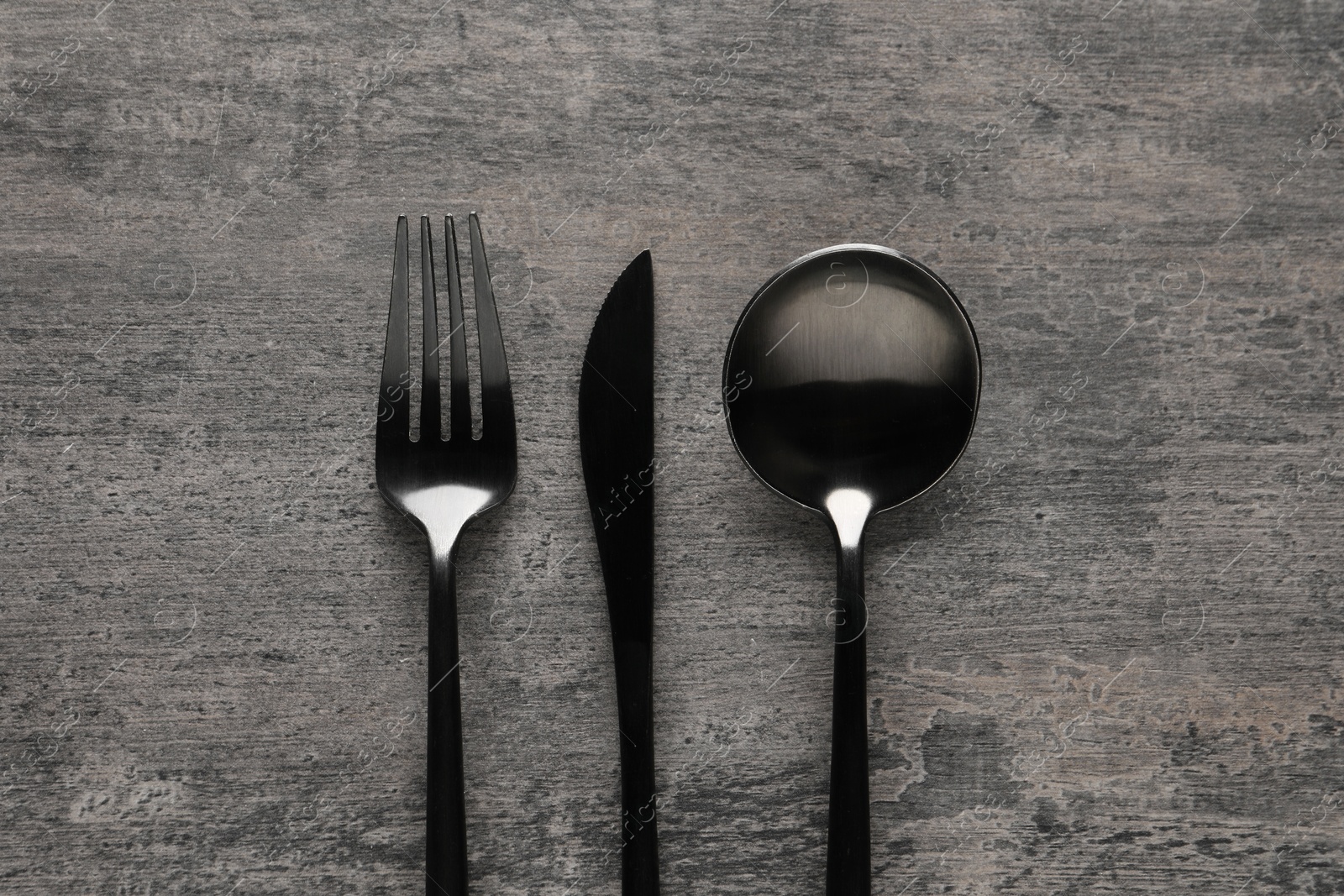 Photo of Stylish cutlery on grey table, flat lay