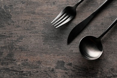 Photo of Stylish cutlery on grey table, flat lay. Space for text