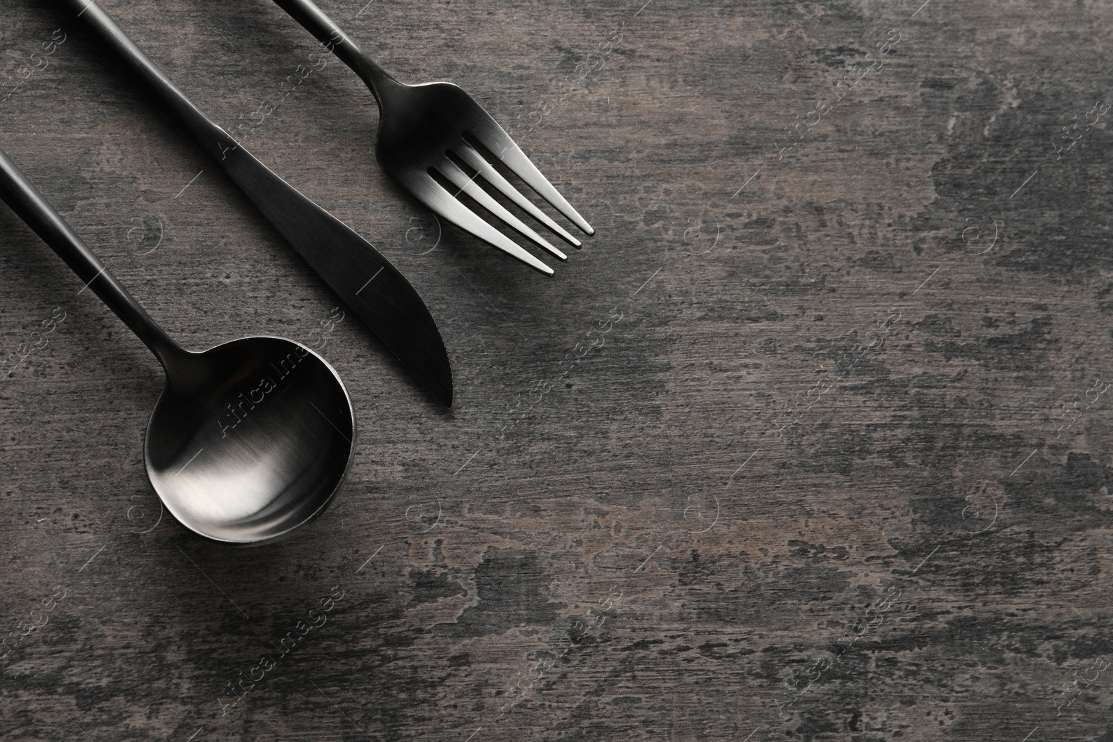 Photo of Stylish cutlery on grey table, flat lay. Space for text