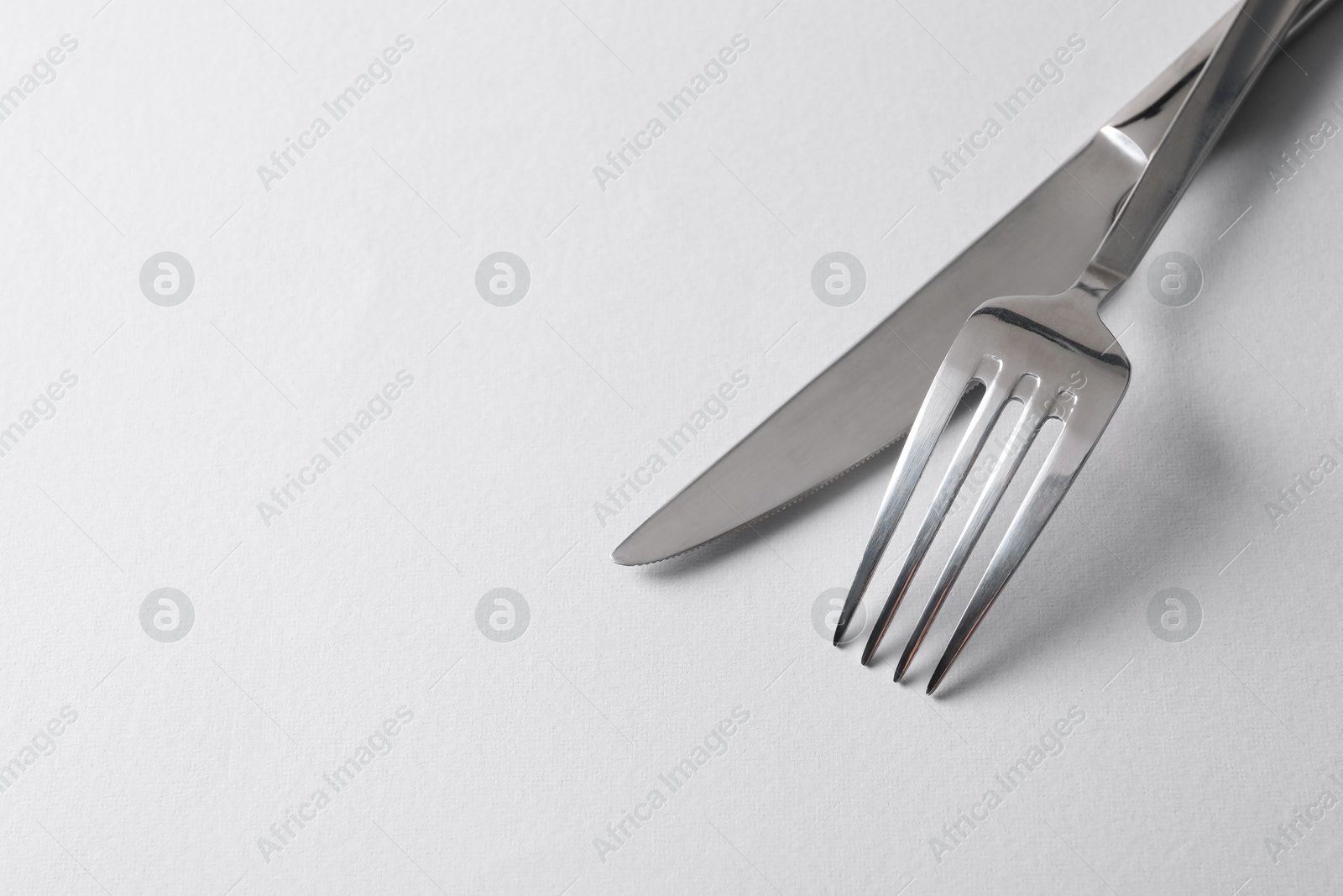 Photo of Stylish silver cutlery on white background, space for text