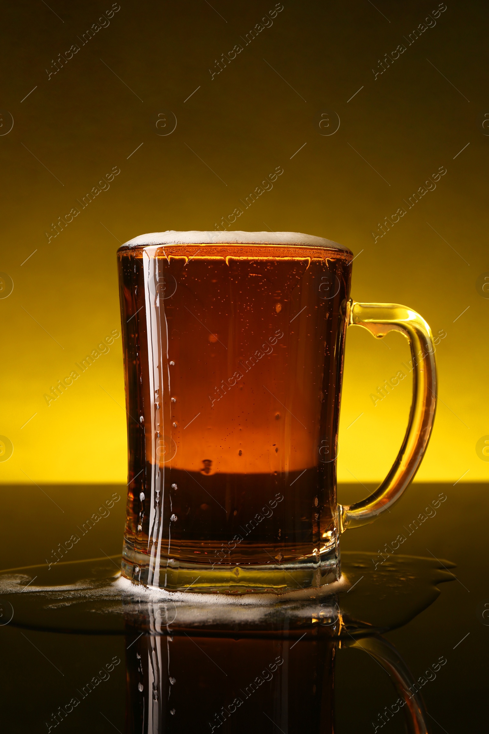 Photo of Glass of beer with froth on dark table, closeup