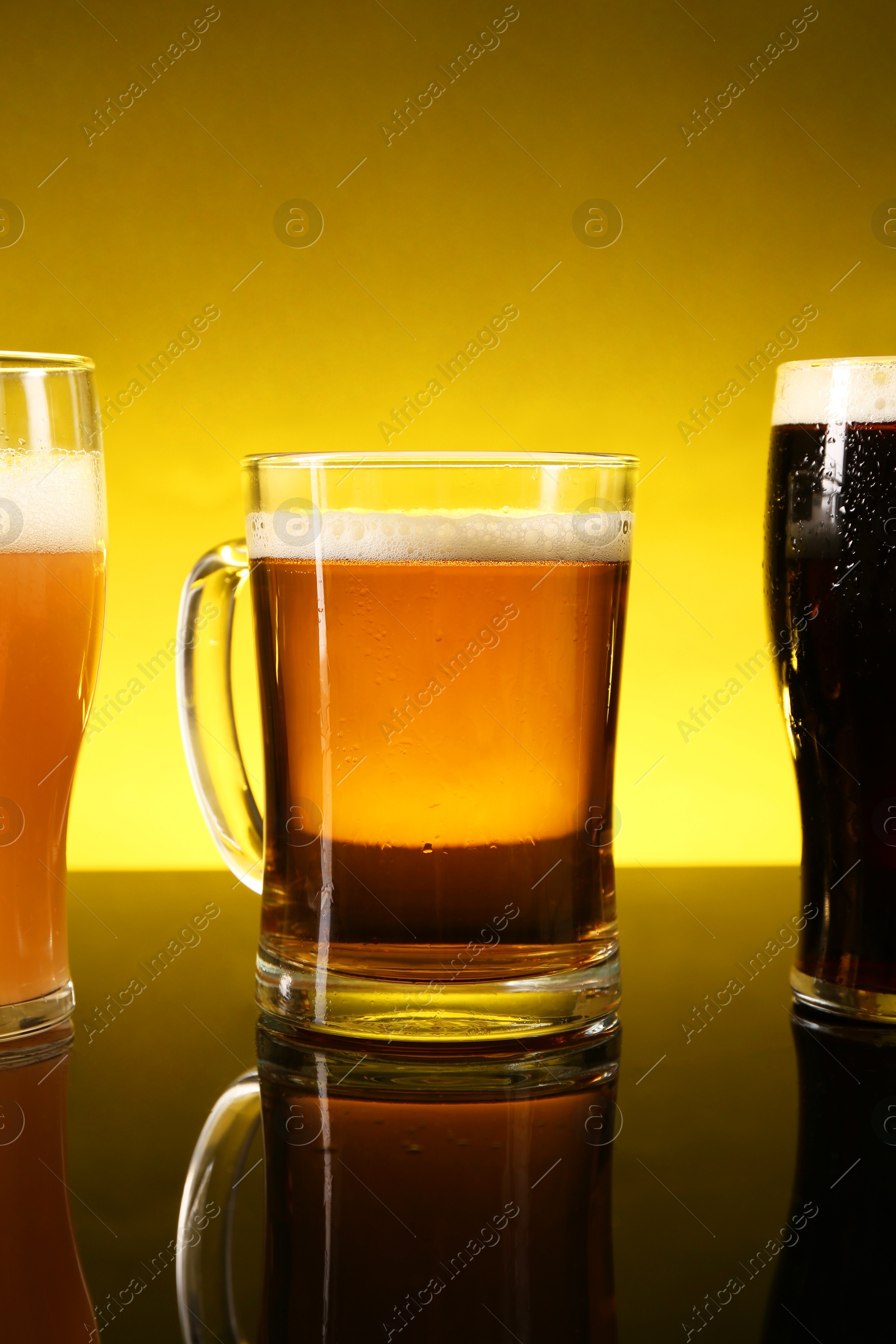 Photo of Glasses with different types of beer on dark table, closeup