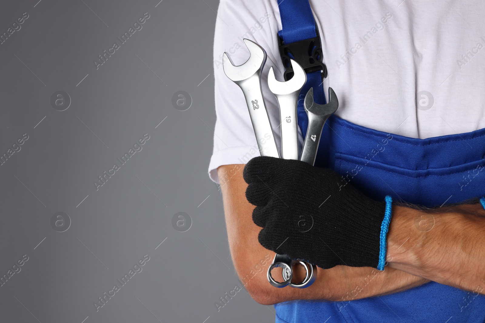 Photo of Auto mechanic with wrenches on grey background, closeup. Space for text