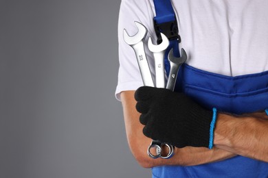 Photo of Auto mechanic with wrenches on grey background, closeup. Space for text