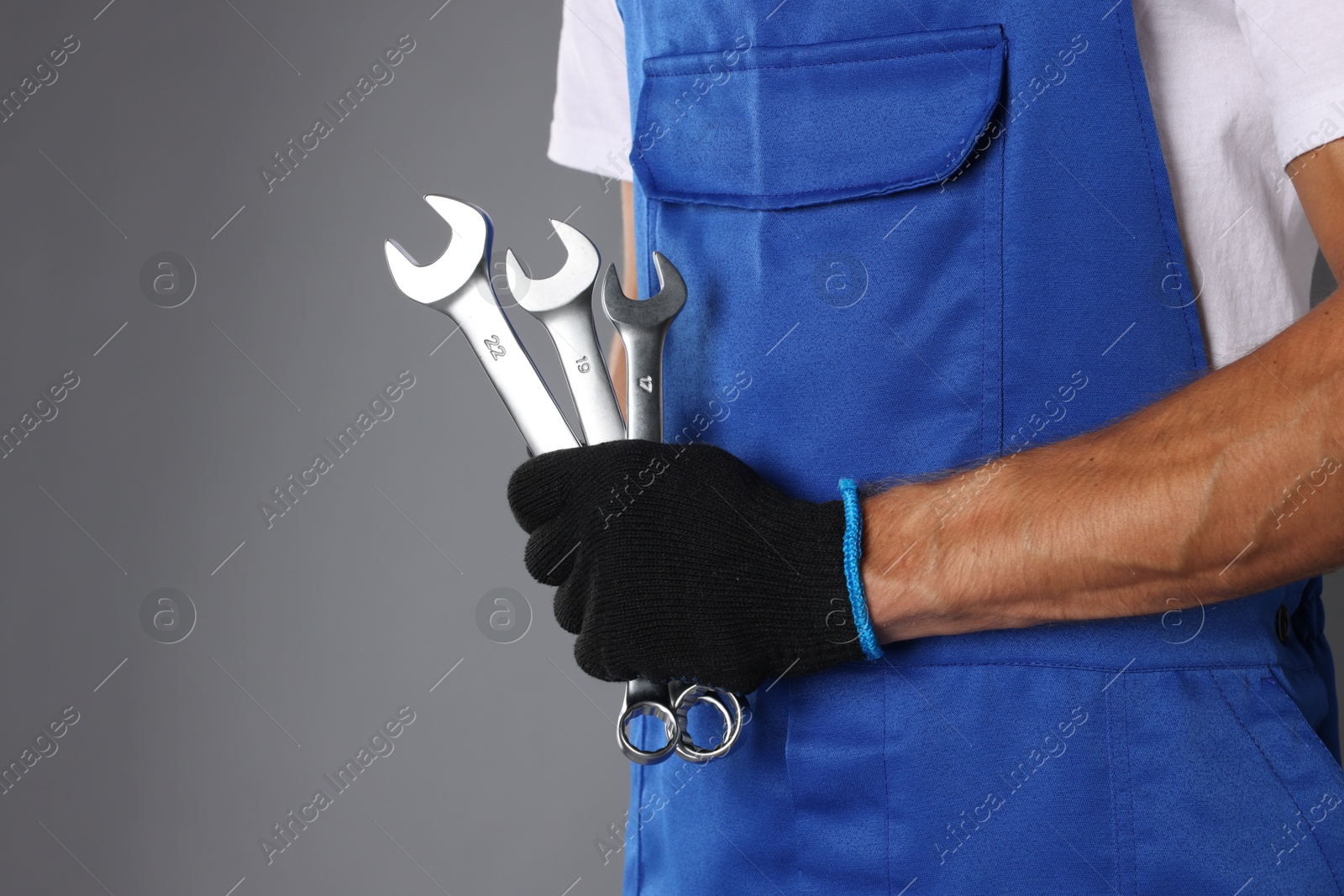 Photo of Auto mechanic with wrenches on grey background, closeup. Space for text