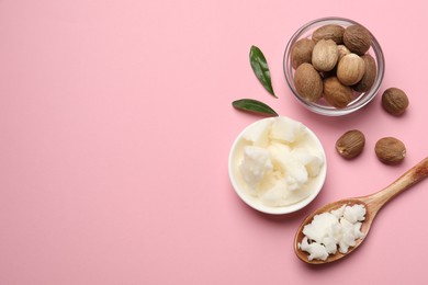 Photo of Natural shea butter in bowl, spoon and nuts on pink background, flat lay. Space for text