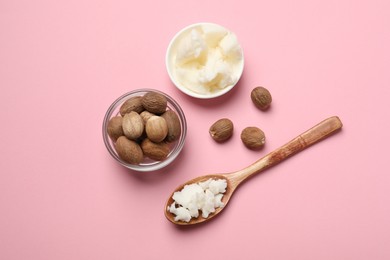 Natural shea butter in bowl, spoon and nuts on pink background, top view