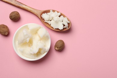 Natural shea butter in bowl, spoon and nuts on pink background, top view. Space for text