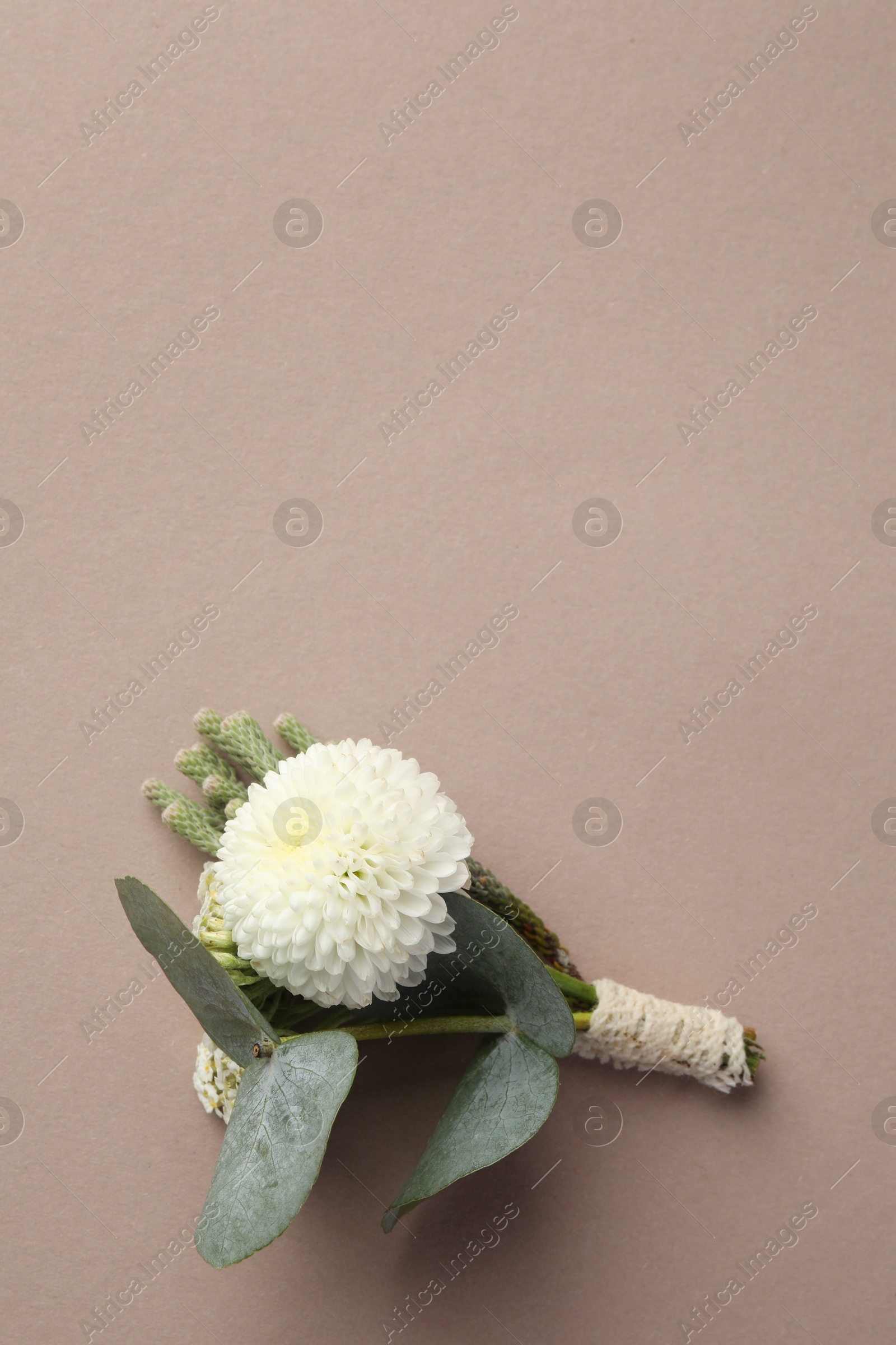 Photo of Small stylish boutonniere on beige background, top view. Space for text