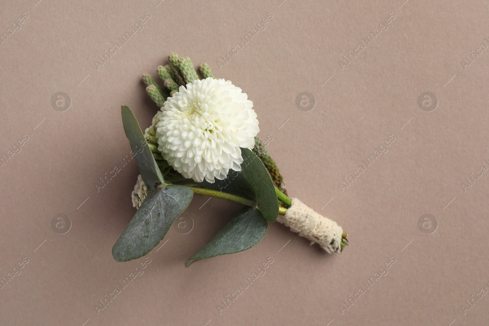 Photo of Small stylish boutonniere on beige background, top view