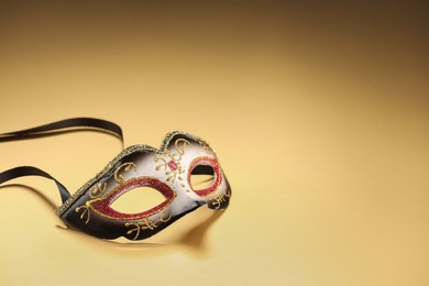 Elegant face mask on beige background, space for text. Theatrical performance