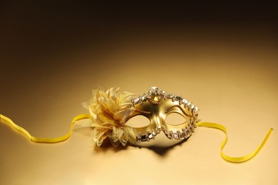 Photo of Beautifully decorated face mask on beige background, space for text. Theatrical performance