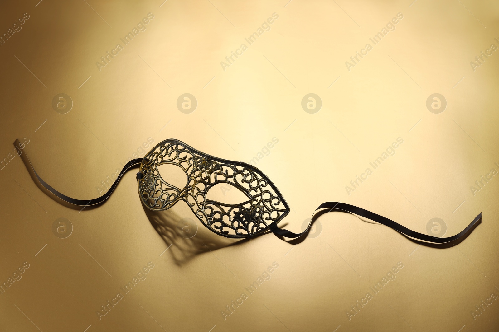 Photo of Elegant face mask on beige background, space for text. Theatrical performance