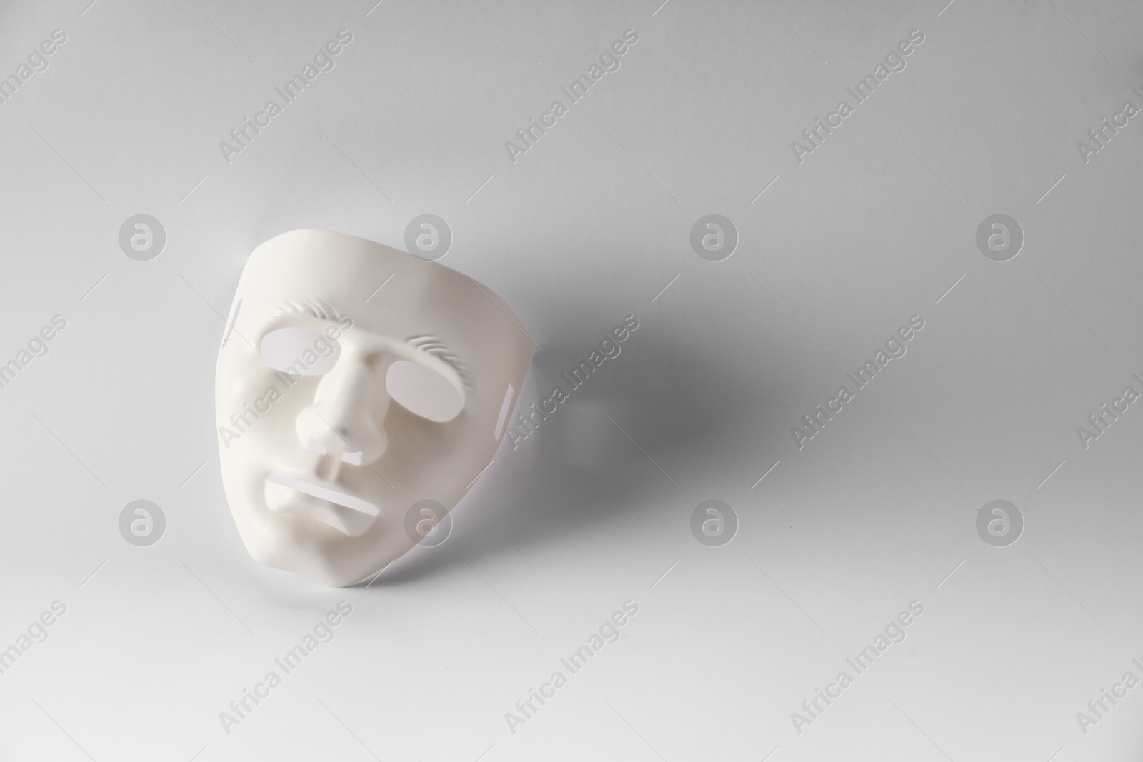 Photo of Plastic face mask on white background, space for text. Theatrical performance